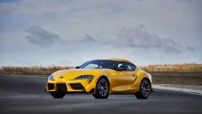 A yellow 2022 Toyota Supra 2.0 shot from the 3/4 angle on a racetrack