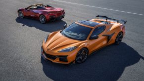 A pair of 2023 Chevrolet Corvette Z06 models, one orange and one red shot from the high 3/4