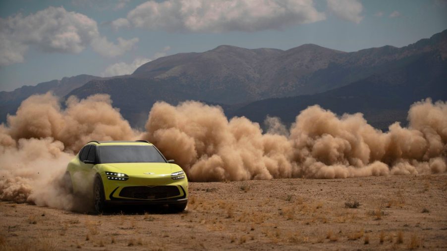 A yellow-green 2023 Genesis GV60 drives through the dirt