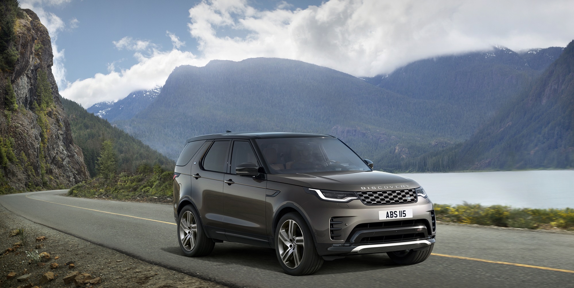 A 2023 Land Rover Discovery Metropolitan Edition drives on a road with a mountainous background