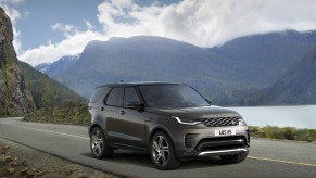 A 2023 Land Rover Discovery Metropolitan Edition drives on a road with a mountainous background