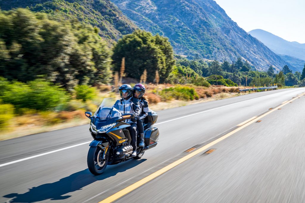 Two riders on a Honda Gold Wing Tour DCT Action riding down the road