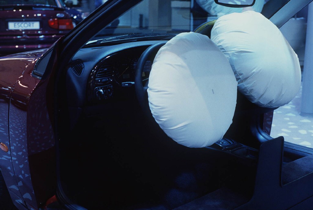 A photo showing a car interior with two airbags deployed