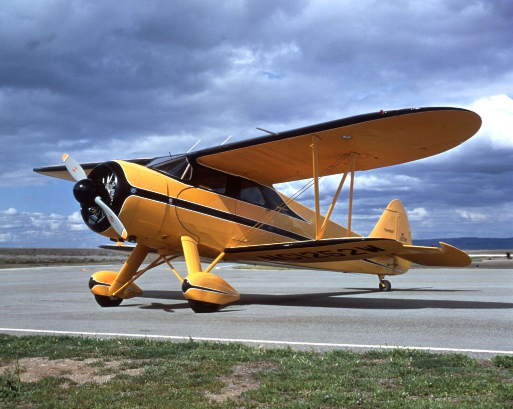 A yellow and black airplane on a runway.