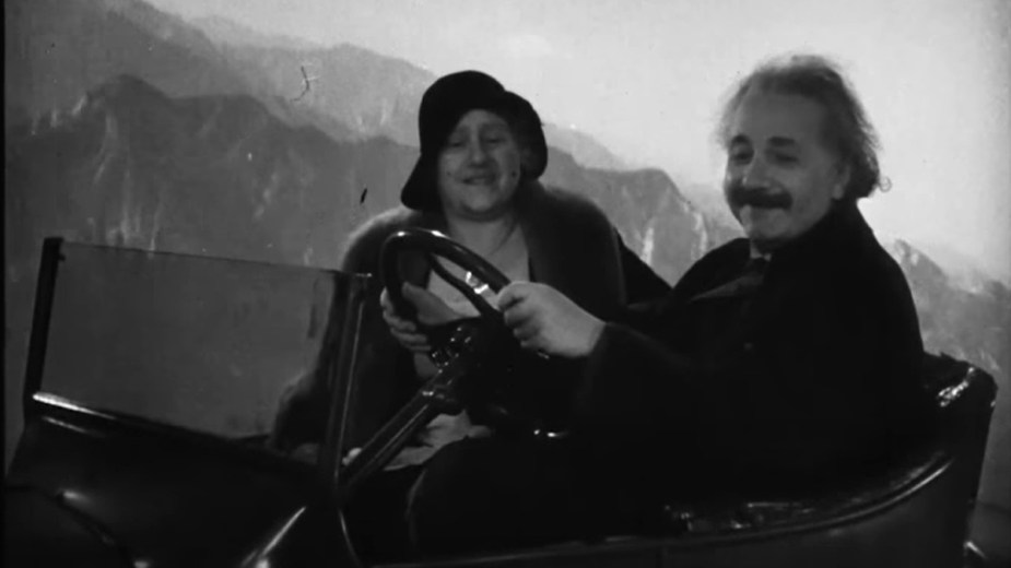 Albert Einstein driving a flying car with his wife on a Warner Brothers soundstage