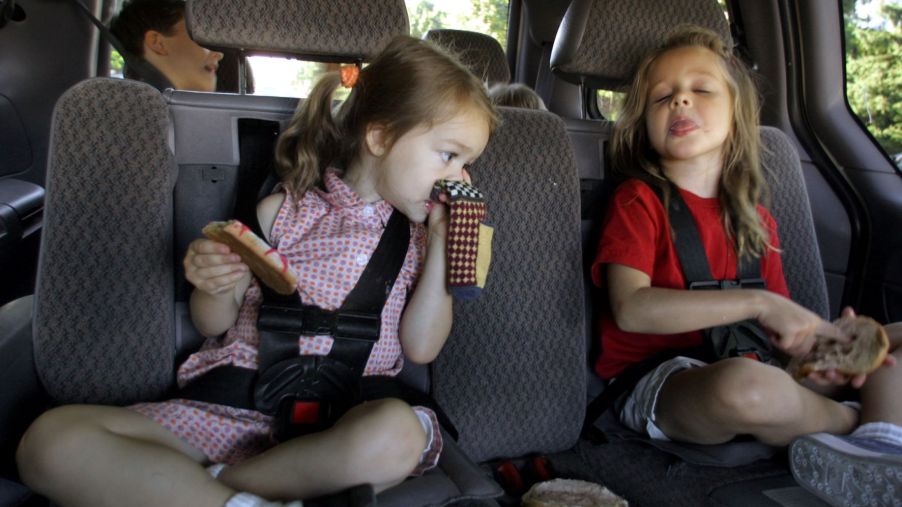 Children backseat of a car making a bad smell expression