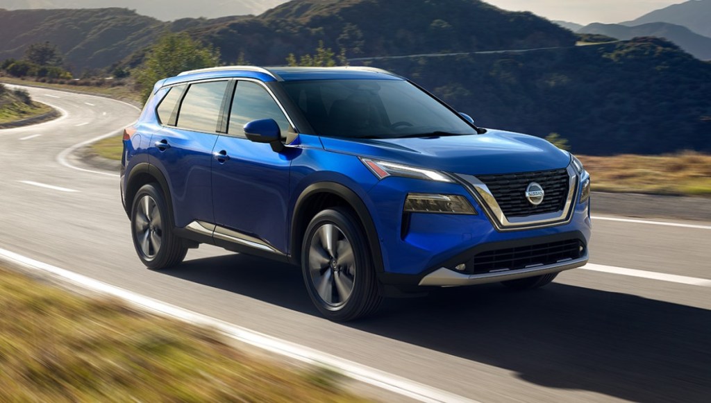 Blue Nissan Rogue driving on a mountainous road