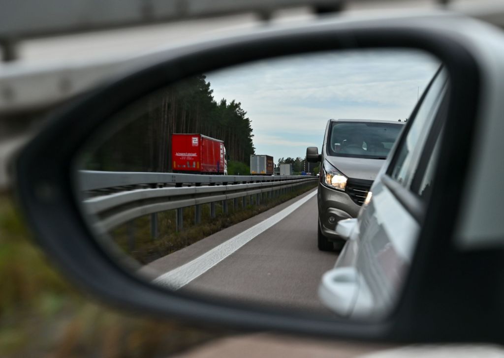 Car rearview mirror with another vehicle in partial view almost in the blind-spot