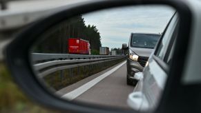 Car rearview mirror with another vehicle in partial view almost in the blind-spot