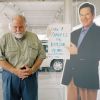 Car salesperson standing next to a cardboard cutout of another car salesperson