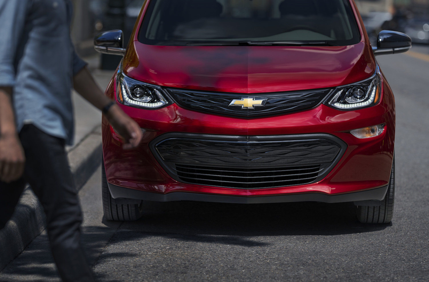 This is a promo photo of a red 2020 Chevrolet Bolt parked on the street. GM announced an additional Chevy Bolt recall, based on unsafe floormats. | General Motors