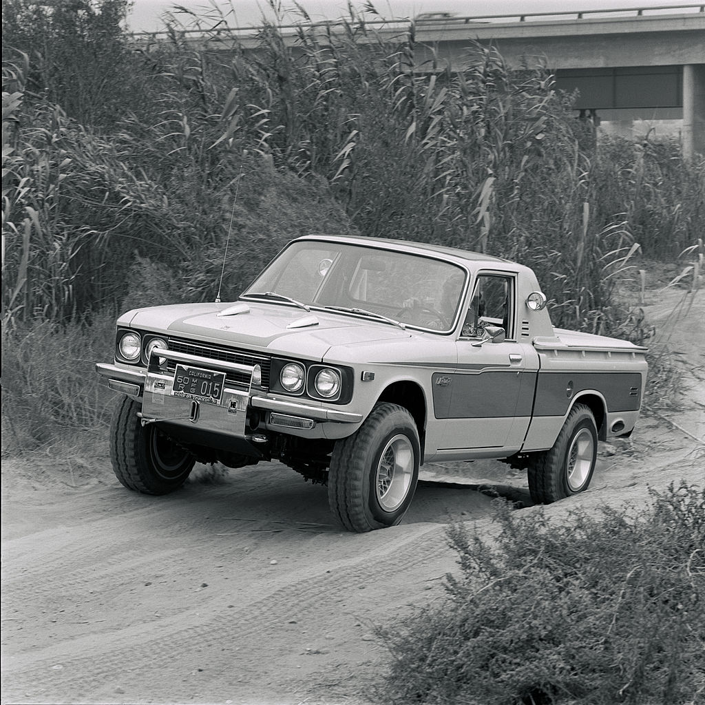 A Chevrolet LUV pickup truck driving off-road near tall grass