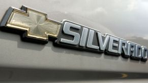 A Chevy Silverado logo on a beige colored truck.