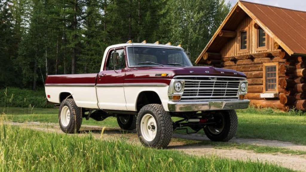 Classic 1969 Ford F-100 truck parked in front of a log cabin