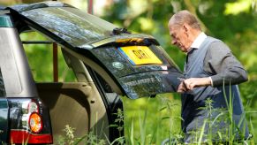A man closing the trunk of his vehicle.