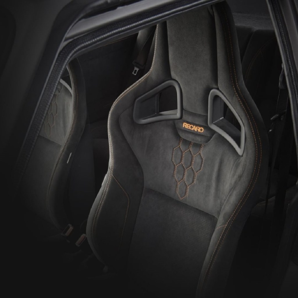 The Alcantara-upholstered black-with-orange-stitching Recaro front seats in a GCK Exclusiv-e Lancia Delta Integrale Evo-e