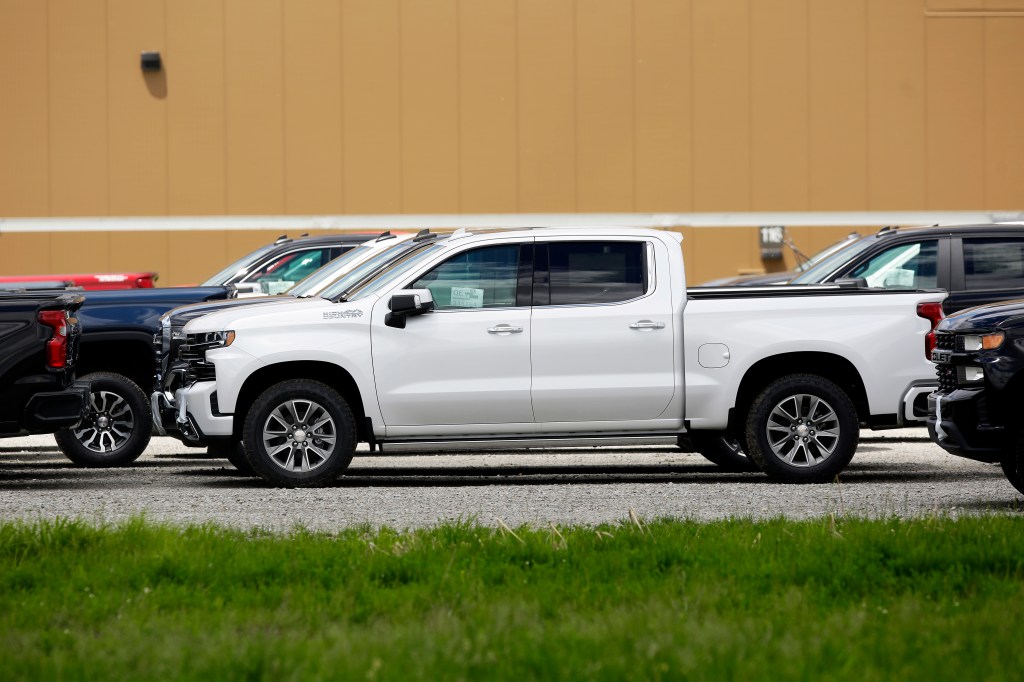A white 2019 GMC Sierra 1500 parked among a sea of Sierra 1500 and Chevy Silverado models. We recommend buying this model year used.