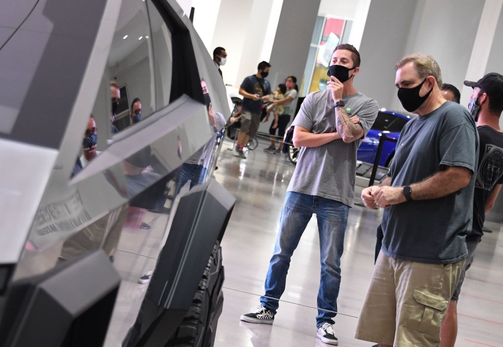 This is a photo of fans look at a Tesla Cybertruck prototype on display at the Petersen automotive museum. A new Tesla Cybertruck prototype was recently spotted, demonstrating how the Cybertruck body will change.  | ROBYN BECK/AFP via Getty Images