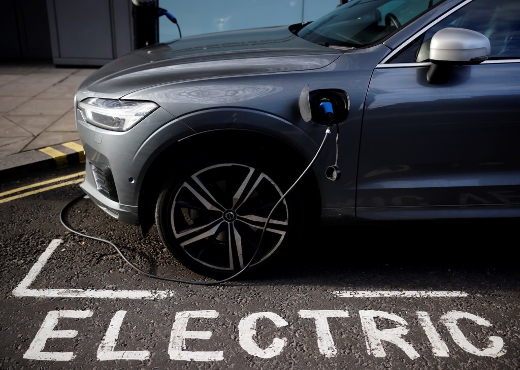 A photo of a charging cable plugged into a Volvo electric vehicle in London. Volvo Stock Story: How It’s Valuation Grew 10x in 10 Years. | TOLGA AKMEN/AFP via Getty Images