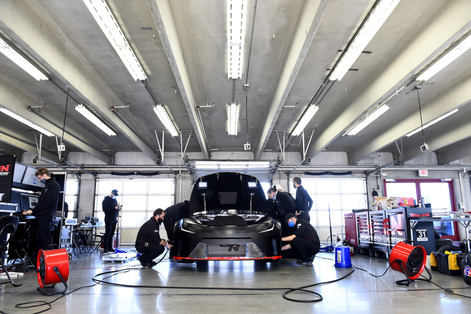 These are NASCAR team members trying to cool down the Next Generation prototype. The NASCAR Next Gen car is in the garage in North Carolina. | Jared C. Tilton/Getty Images
