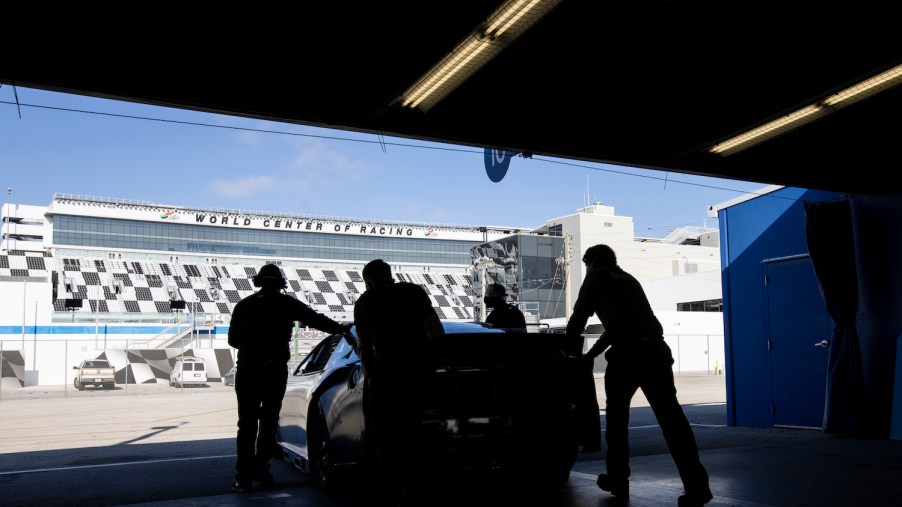 These are team members pushing the NASCAR Next Gen car prototype out of the garage at Daytona. After a NASCAR Next Gen crash test went poorly, delivery of chassis, and information, to the teams was delayed. | James Gilbert/Getty Images