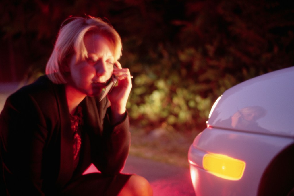 This is a photo of a woman examining the front of her sedan and calling for help. 466,000 Sonata sedans are at risk of a turn signal malfunction and affected by Hyundai recall.  Doug Wilson/CORBIS/Corbis via Getty Images