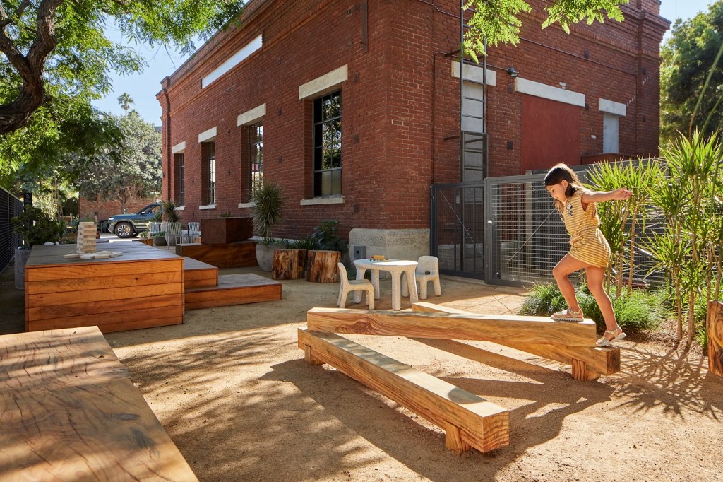 Girl playing on playground equipment at the Venice Rivian Hub