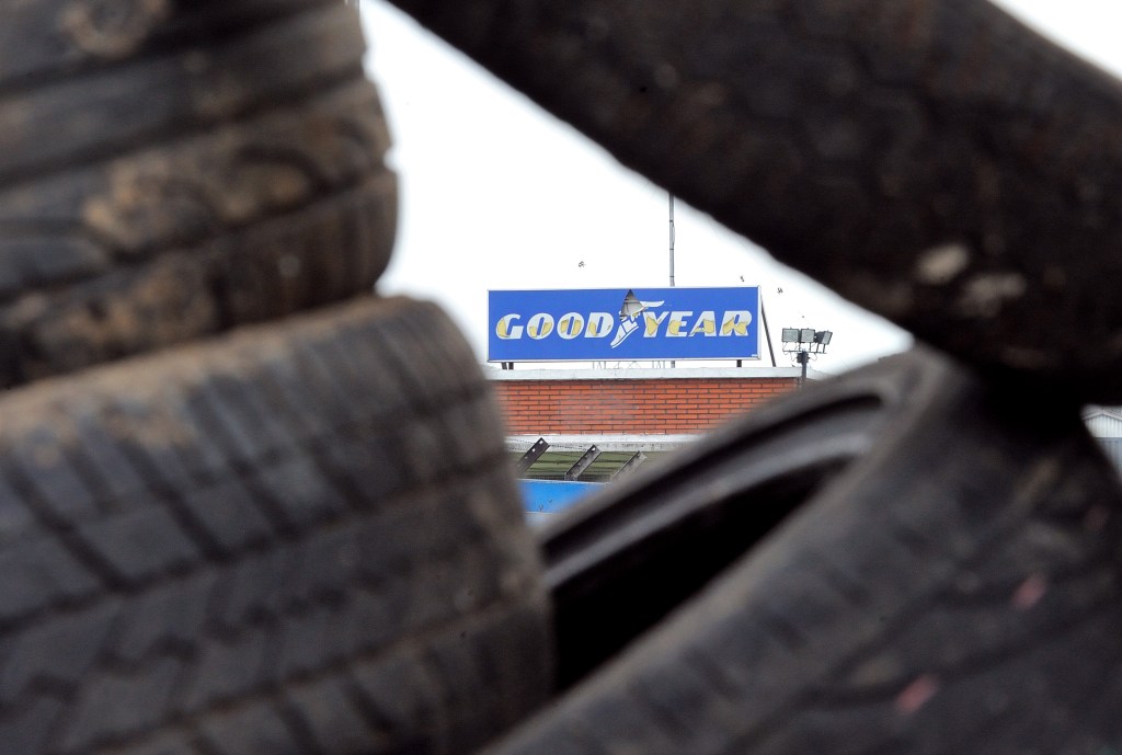 Goodyear Logo Peeking Through Pile Of Tires