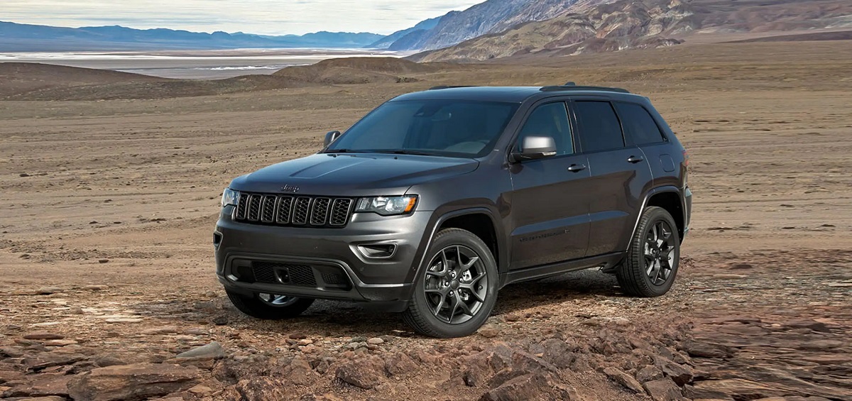A gray 2021 Jeep Grand Cherokee parked on a plain.