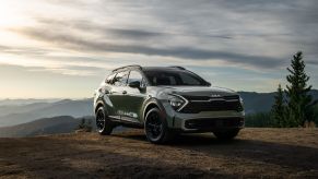 Green 2023 Kia Sportage with mountains in the background