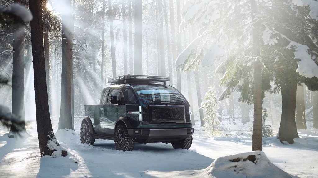 Green Canoo Pickup parked in a snowy forest