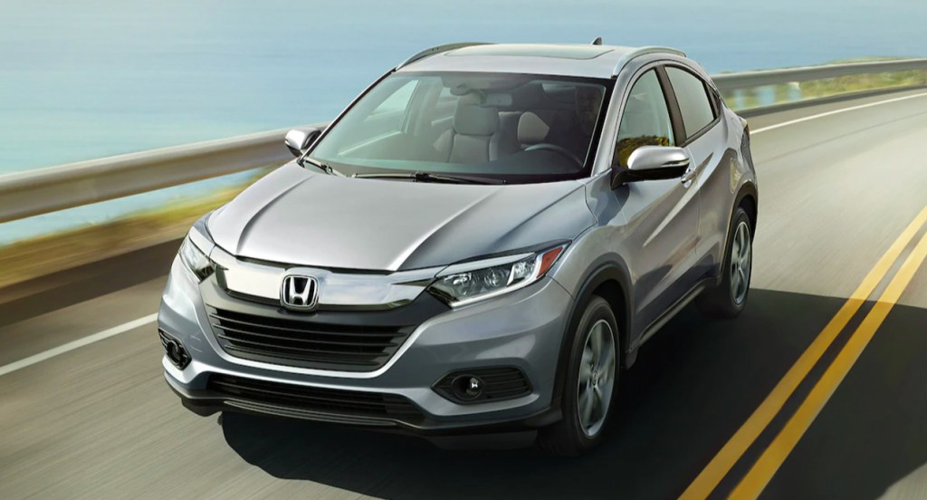 A silver Honda HR-V is driving on the road. 