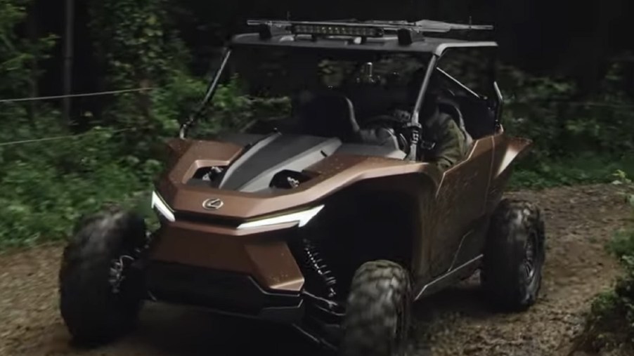 The copper-and-black Hydrogen-powered Lexus Recreational Off-Highway Vehicle Concept drives through a muddy forest