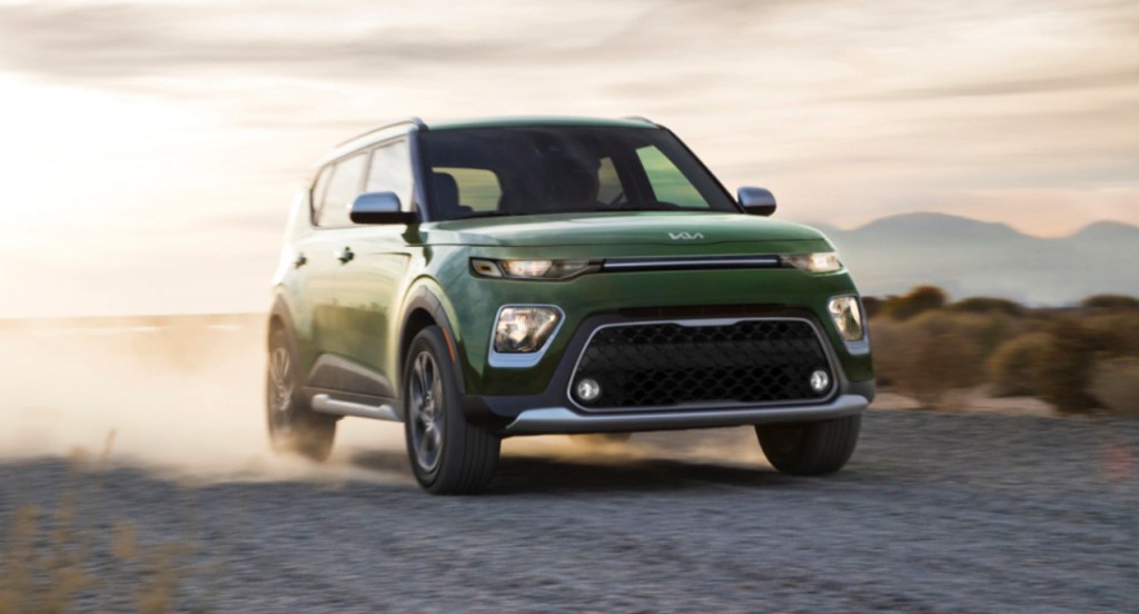 A green 2022 Kia Soul is driving on the road. 