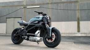 The blue-and-black JvB Moto 'Silent Alarm' custom 2020 Harley-Davidson LiveWire next to an industrial garage
