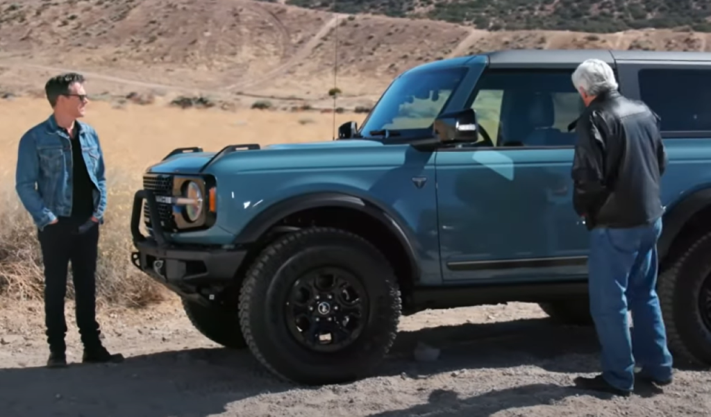 Kevin Bacon and Jay Leno standing next to a blue 2021 Ford Bronco Sasquatch