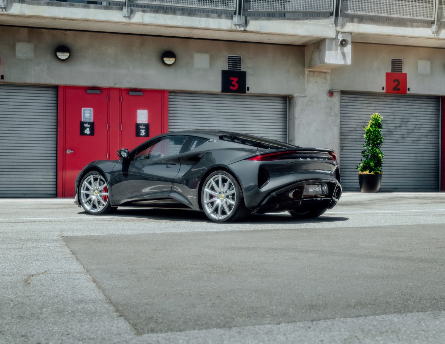 The Lotus Emira supercar parked in a strip of storage garages