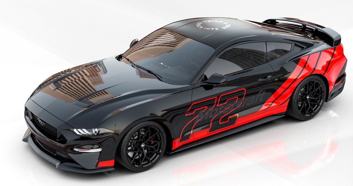 A black 2021 Ford Mustang GT with red stripe graphics, a front splitter and rear wing spoiler. The wheels are 19 inches and also black. This vehicle will be on display at SEMA 2021