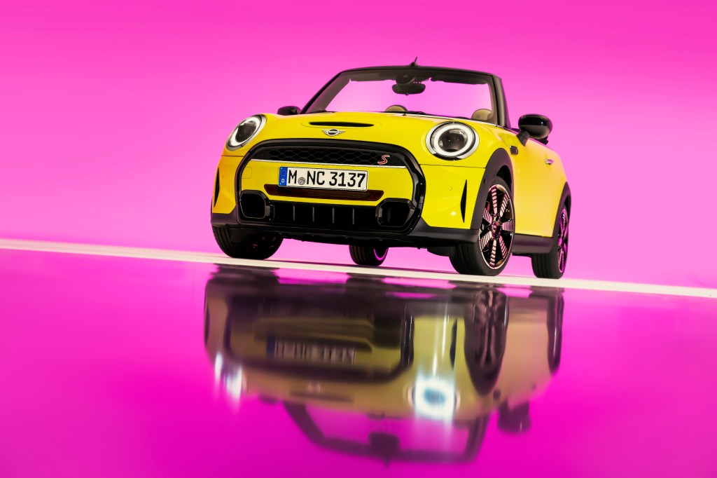 2022 Mini Cooper S convertible in yellow against a pink background