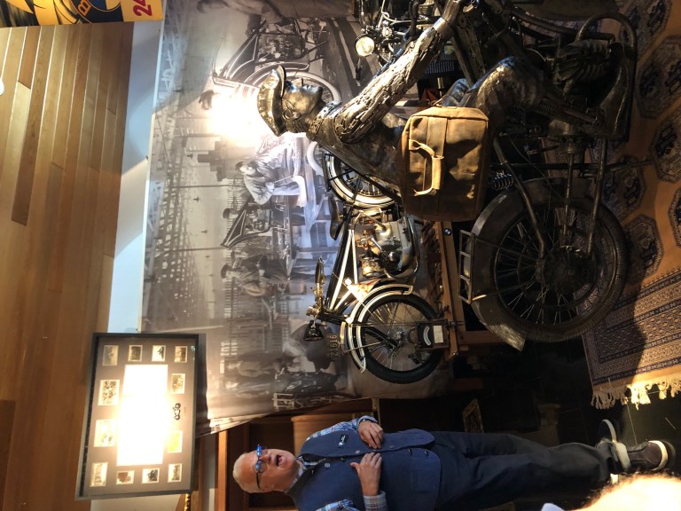 Peter Nettesheim standing with the oldest BMW motorcycle known to man.
