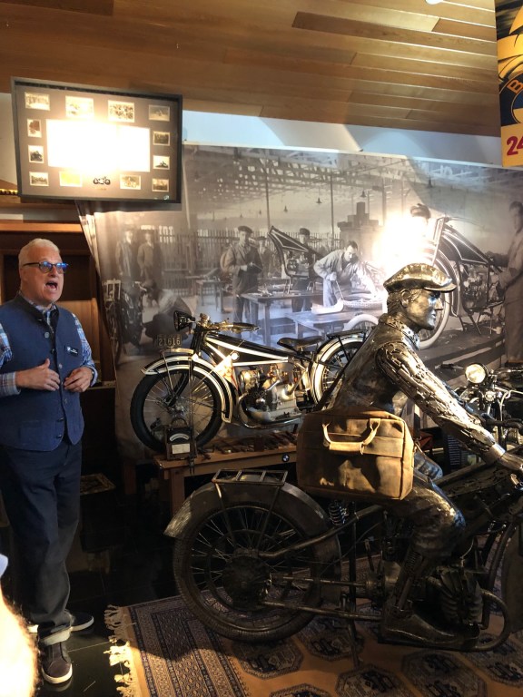 Peter Nettesheim standing with the oldest BMW motorcycle known to man.