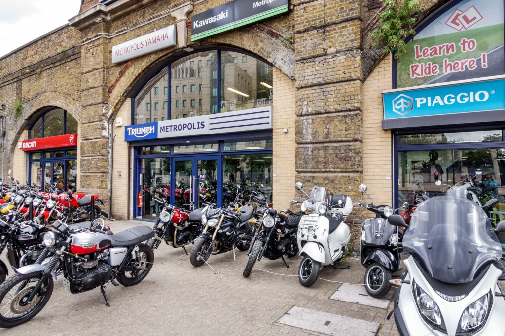 New and used Ducati and Triumph motorcycles and Piaggio scooters in front of a London dealer