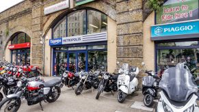 New and used Ducati and Triumph motorcycles and Piaggio scooters in front of a London dealer