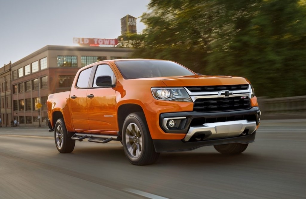 Orange 2022 Chevy Colorado driving down a street, it's one of the best affordable small pickup trucks of 2022.