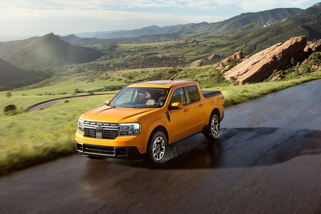 Orange 2022 Ford Maverick compact pickup truck driving on a mountainous road