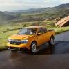 Orange 2022 Ford Maverick compact pickup truck driving on a mountainous road, its newly announced fuel economy rating is superb.