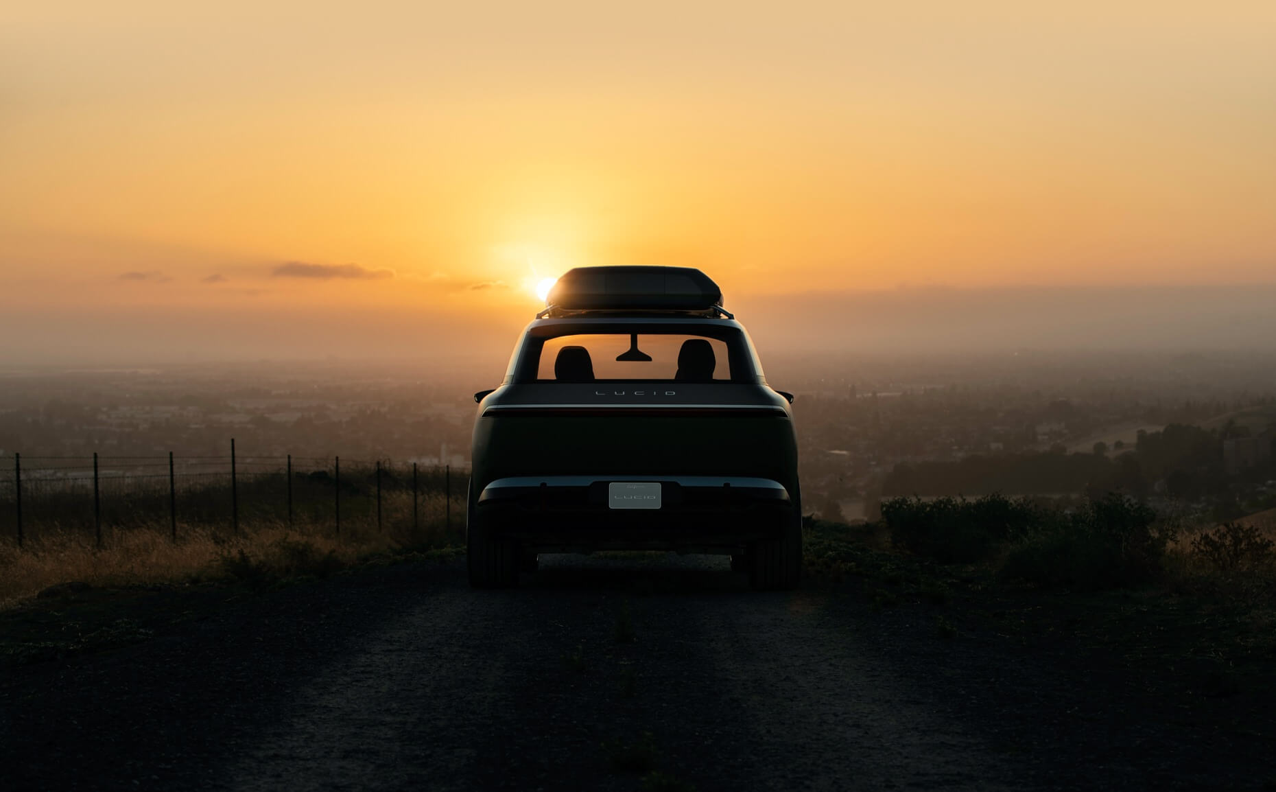 Rear view of Lucid Gravity electric crossover SUV with the sunset in the background