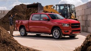 Red 2021 Ram 1500 parked next to piles of dirt