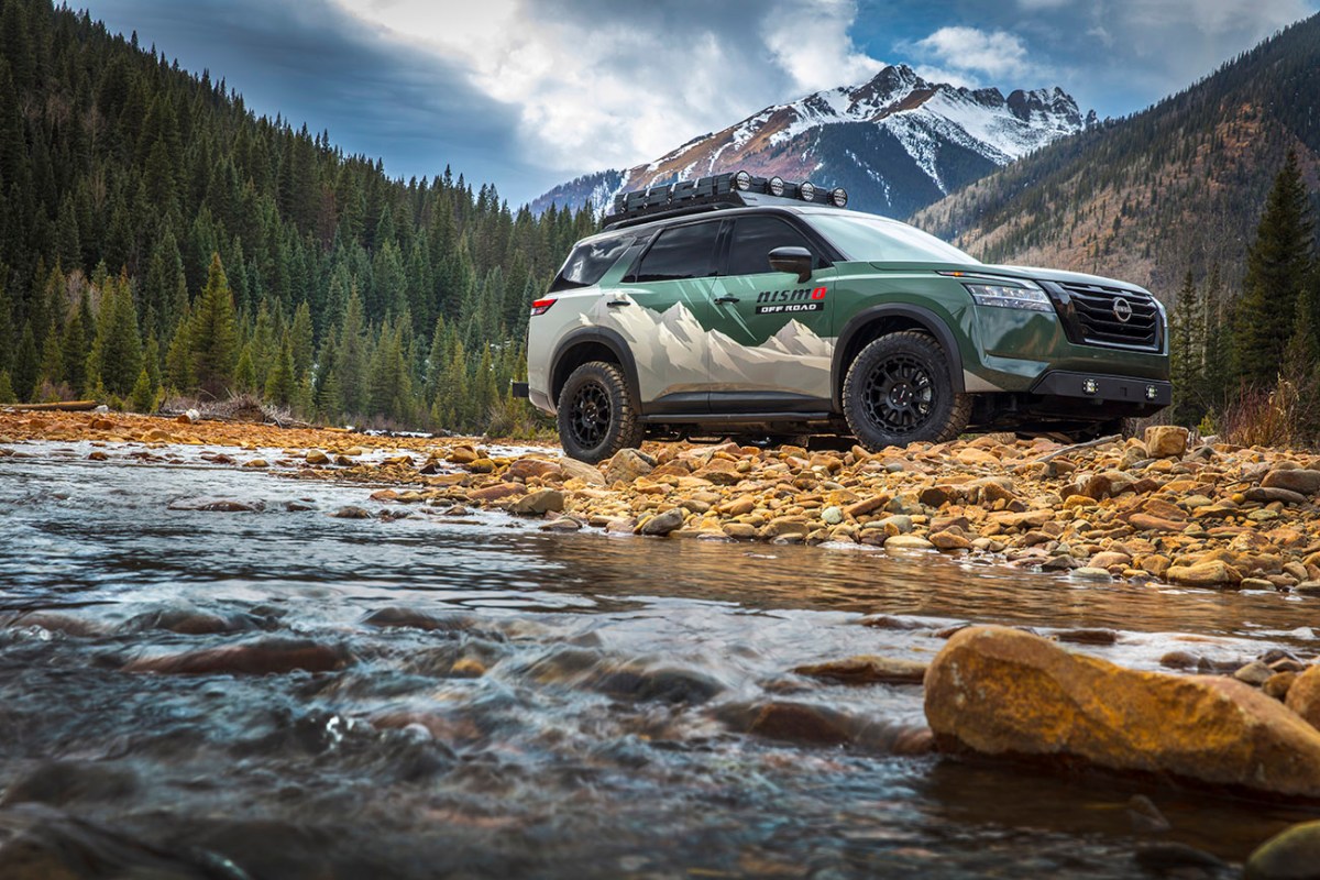 Nissan's Project Overland Pathfinder parked next to a stream. The car will be on display at SEMA 2021