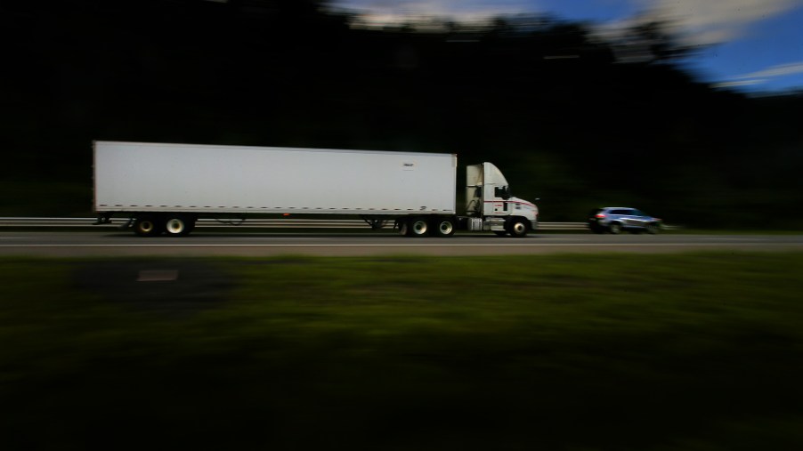 Semi Truck and Car Driving Down Highway